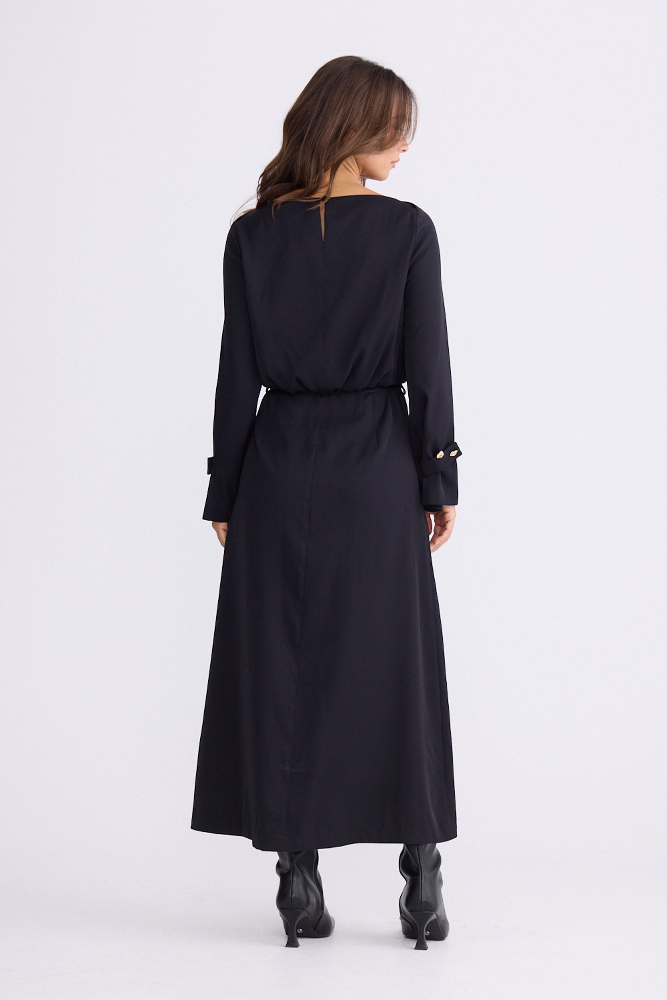 Model wearing Kensington Dress in black with boat neckline and long sleeves, front view on white background
