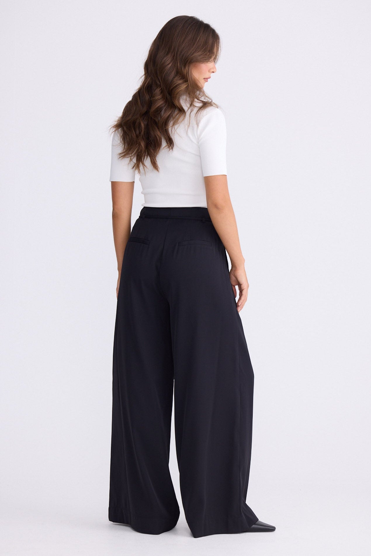 Model wearing Kensington Pant in black with waist tie and wide-leg shape, front view on white background