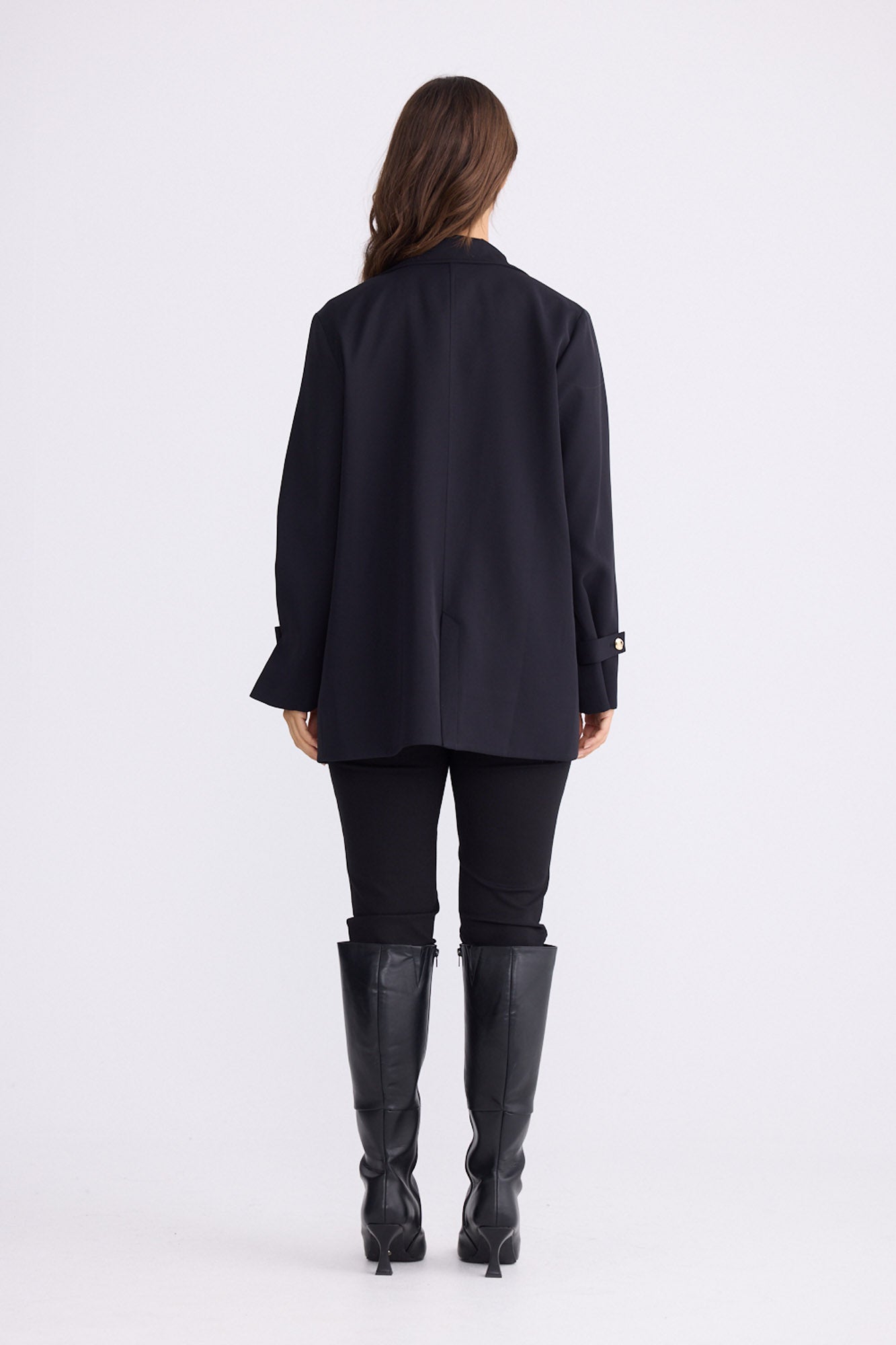 Model wearing Kensington Blazer in black with notched lapels and long sleeves, front view on white background