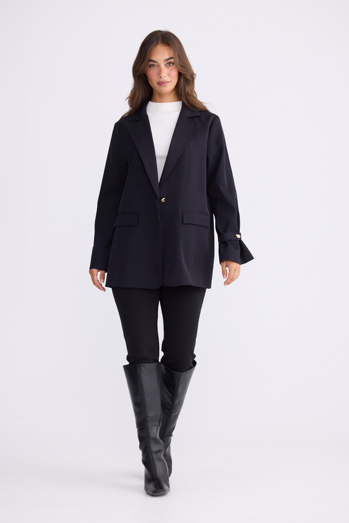 Model wearing Kensington Blazer in black with notched lapels and long sleeves, back view on white background