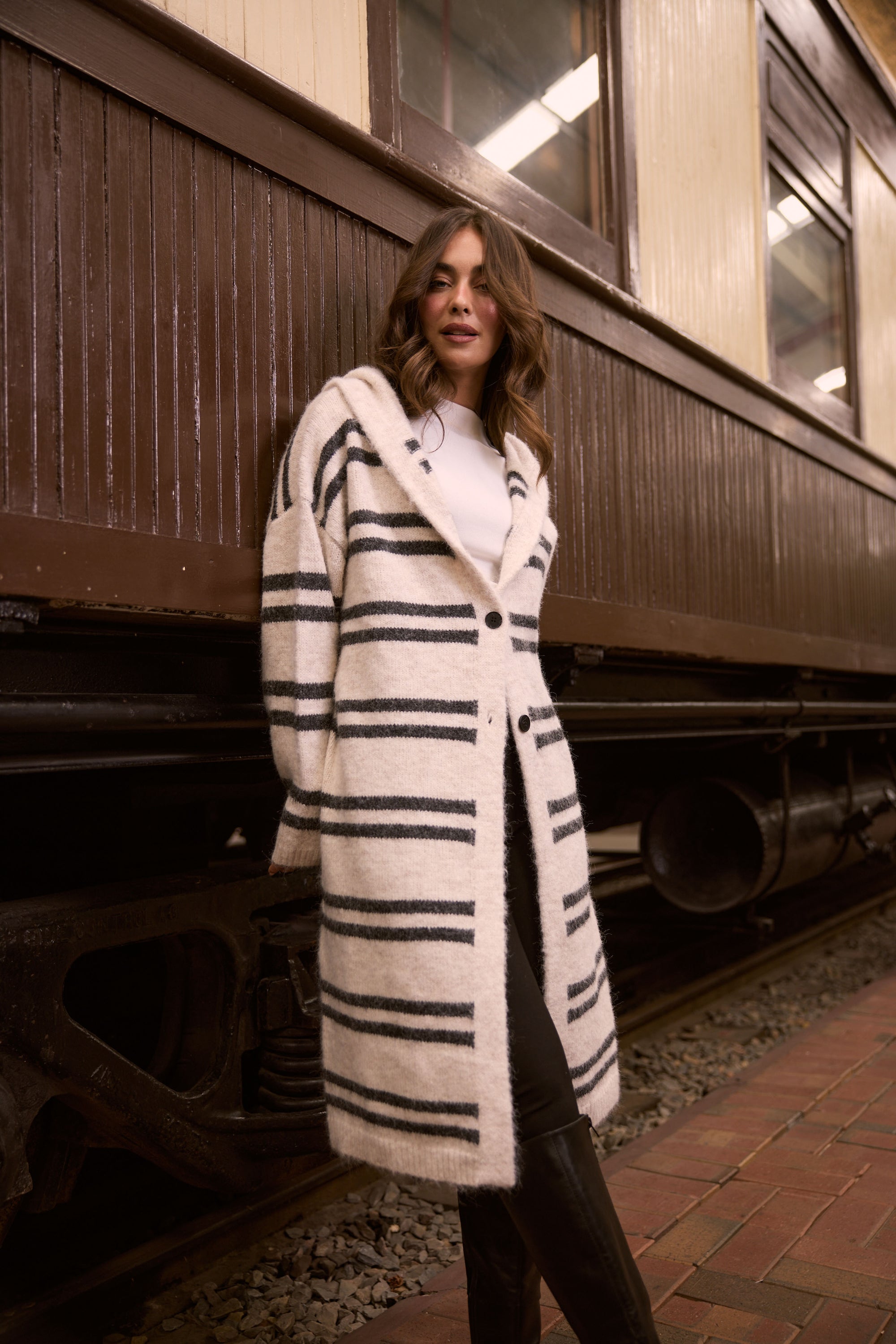 Model wearing Chelsea Knit Cardi - Natural W Grey Stripe, campaign view on white background