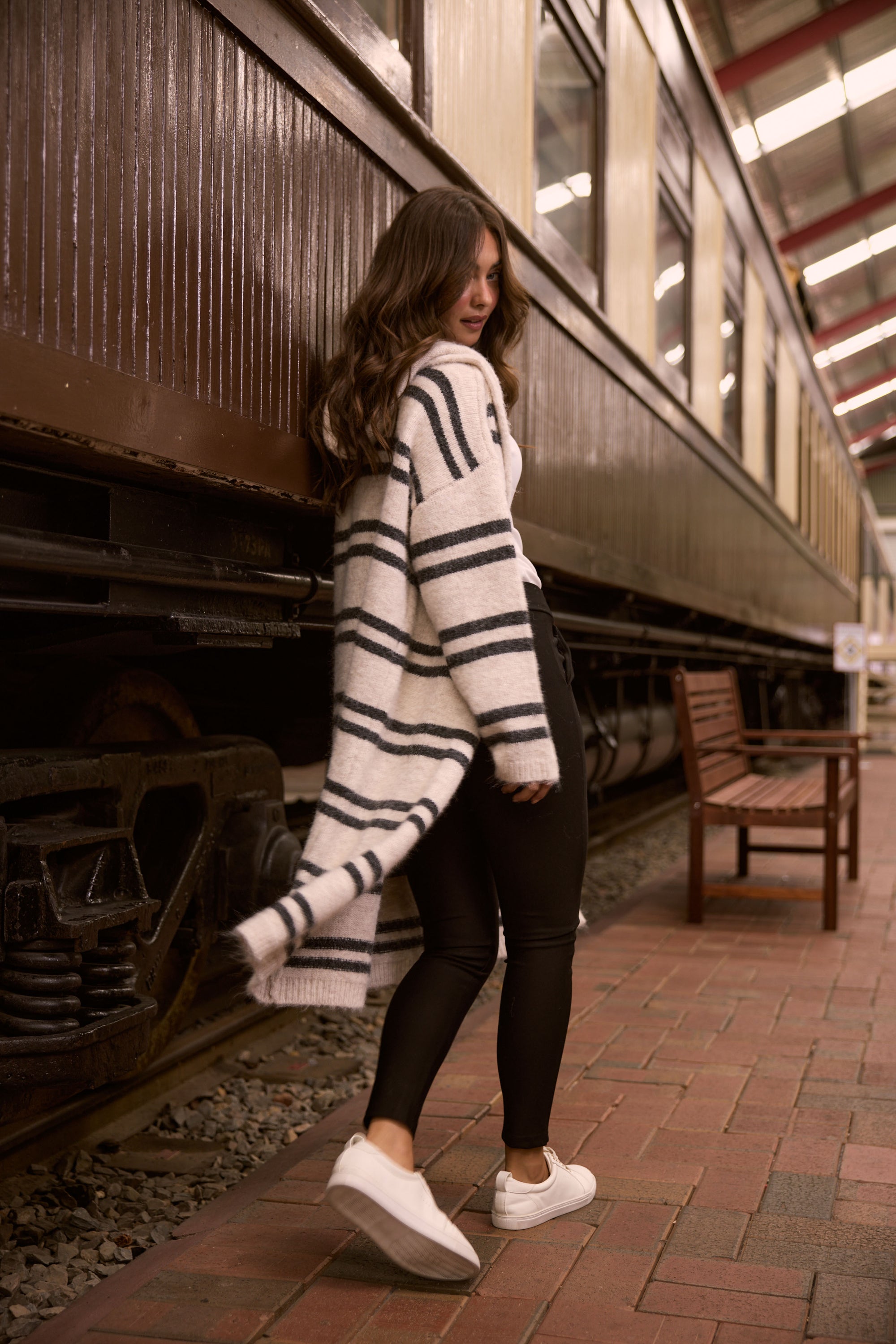 Model wearing Chelsea Knit Cardi - Natural W Grey Stripe, campaign view on white background
