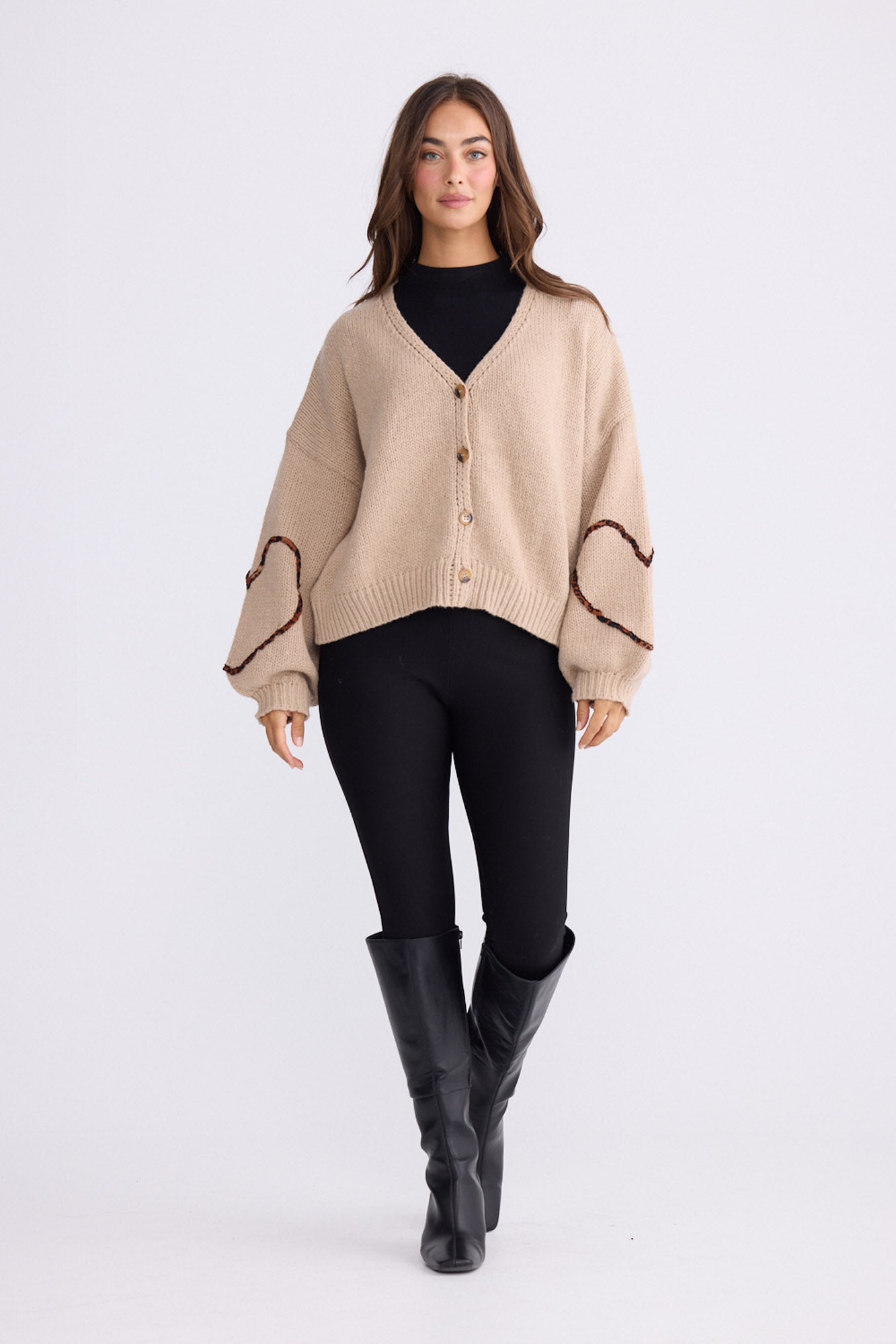 Model wearing Angie Knit Cardi beige cardigan with V-neckline, button-front closure, alternate studio view on white background