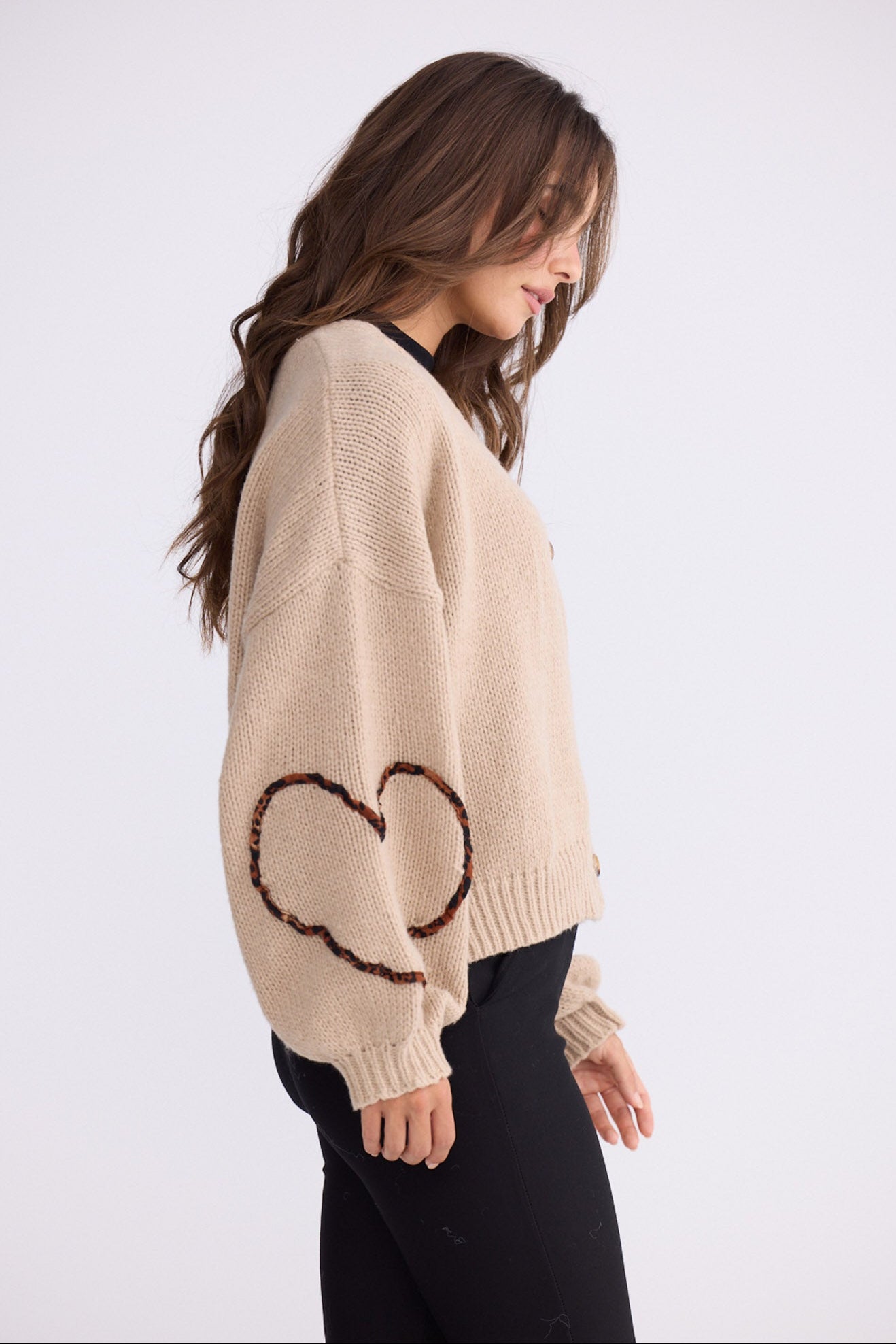 Model wearing Angie Knit Cardi beige cardigan with V-neckline, button-front closure, alternate studio view on white background