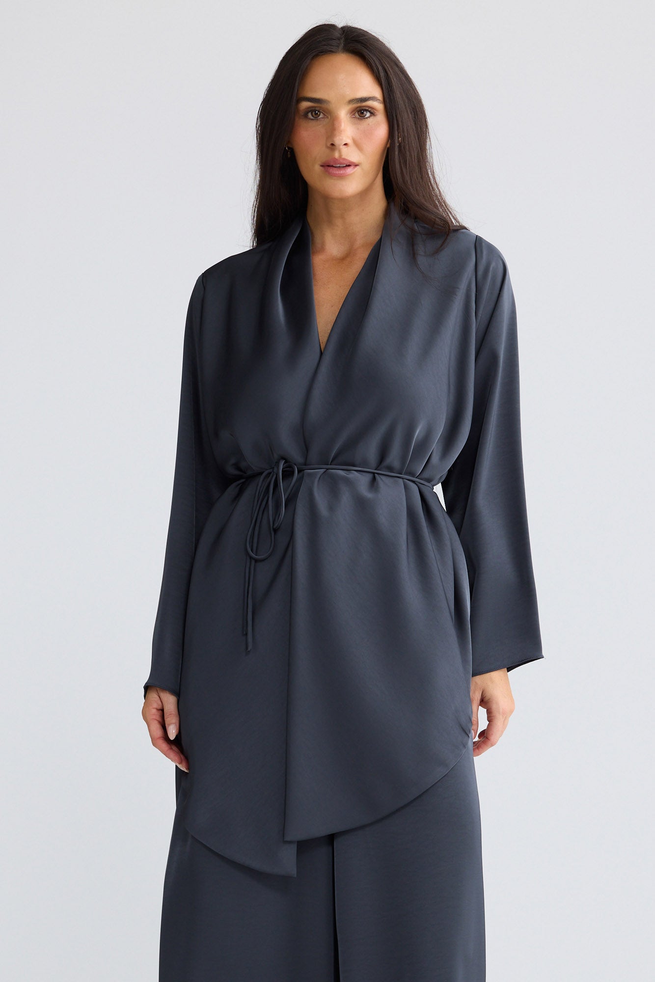 Model wearing Kaleigh Wrap Top in graphite grey by Brave + True, front view showing waist tie.