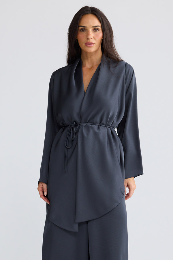 Model wearing Kaleigh Wrap Top in graphite grey by Brave + True, front view showing waist tie.