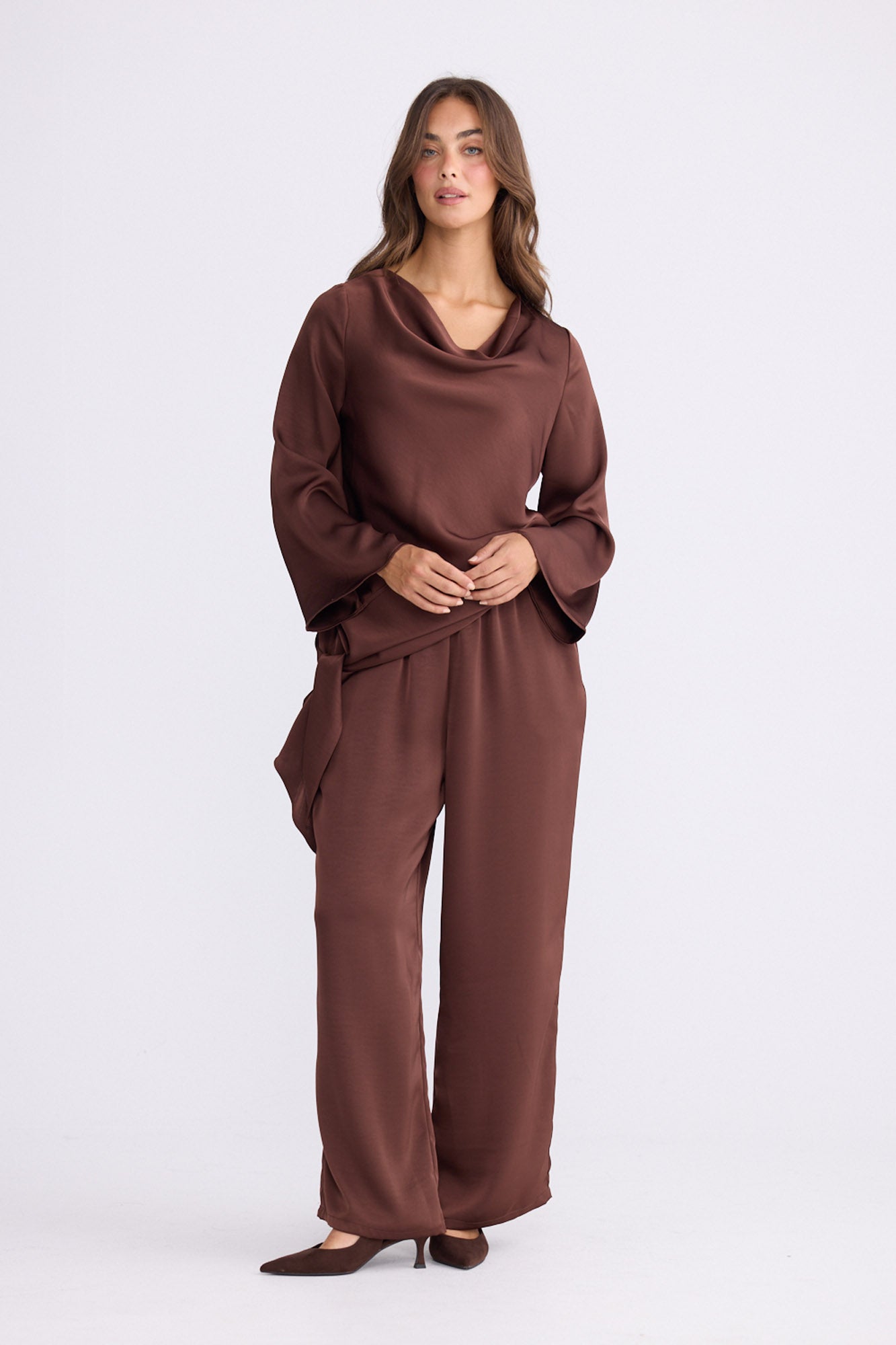 Model wearing Kirsten Top in brown, side view on white background