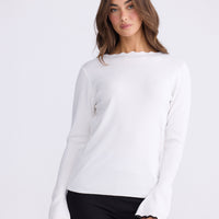 Model wearing Stacey white knit top with scalloped contrast trim, alternate view on white background