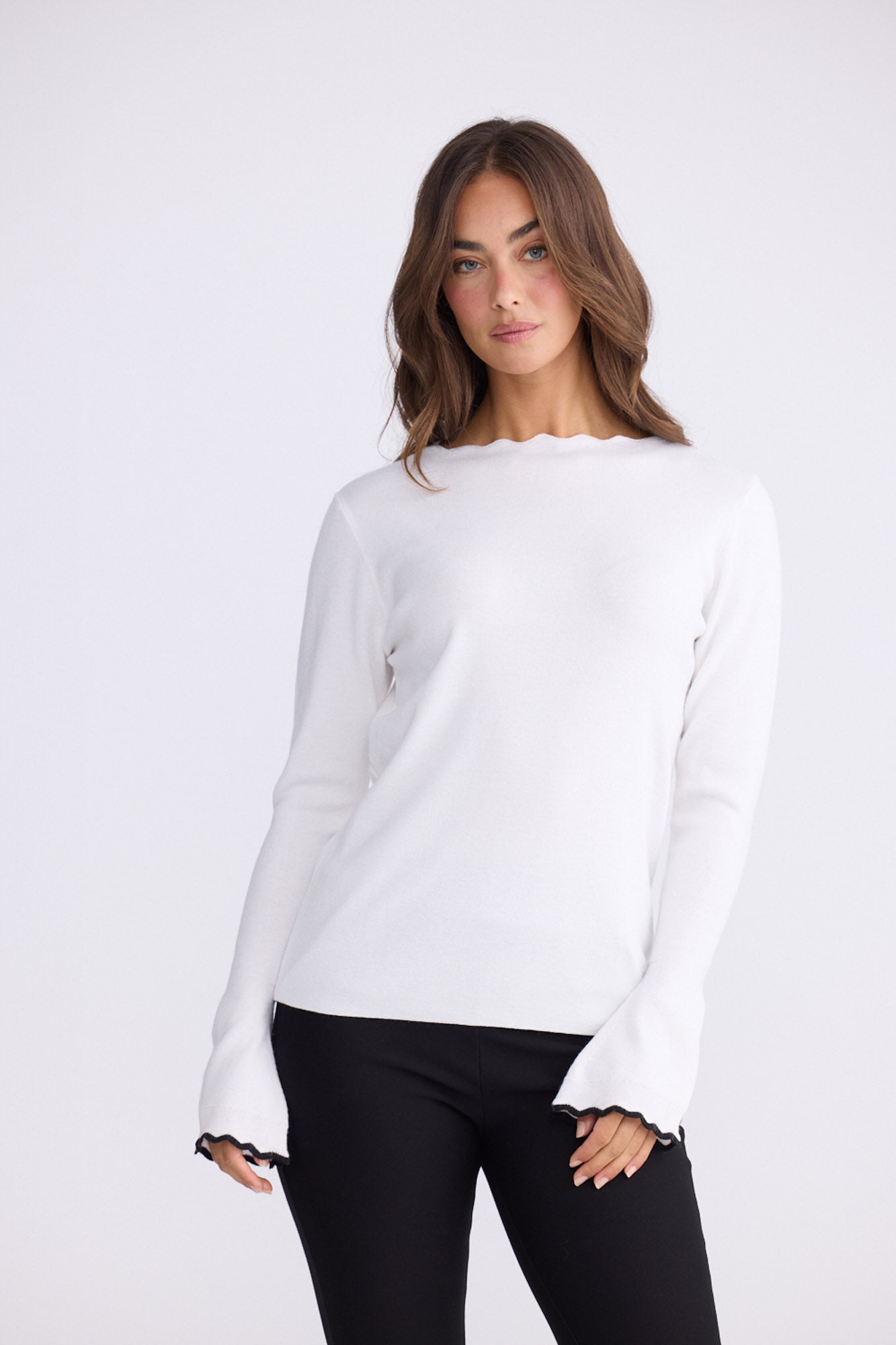 Model wearing Stacey white knit top with scalloped contrast trim, alternate view on white background