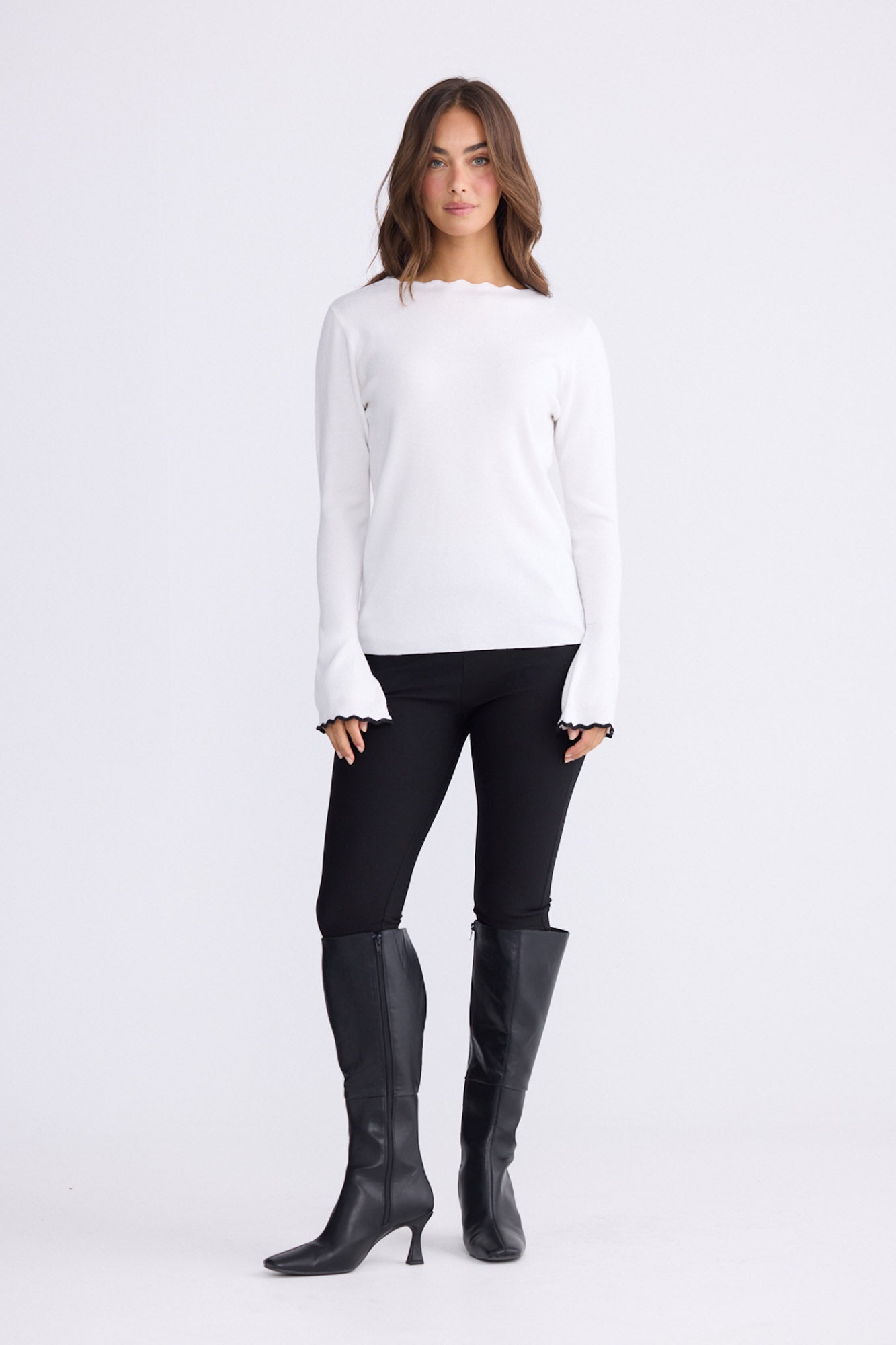 Model wearing Stacey white knit top with scalloped contrast trim, alternate view on white background