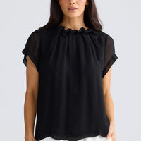 Model wearing Carina Blouse in black by Brave + True, front view showing gathered neckline.