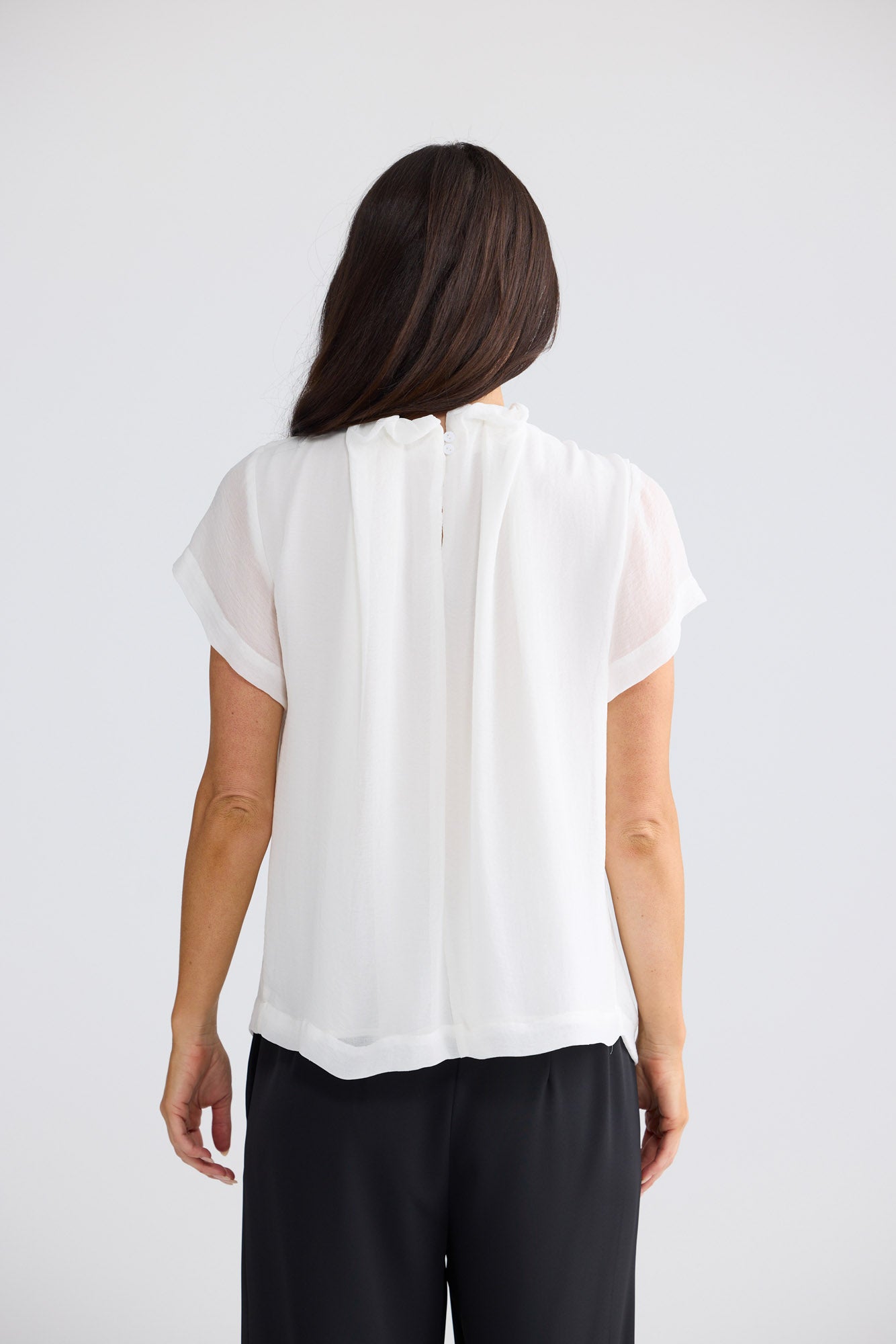 Model wearing Carina Blouse in white by Brave + True, front view showing gathered neckline.