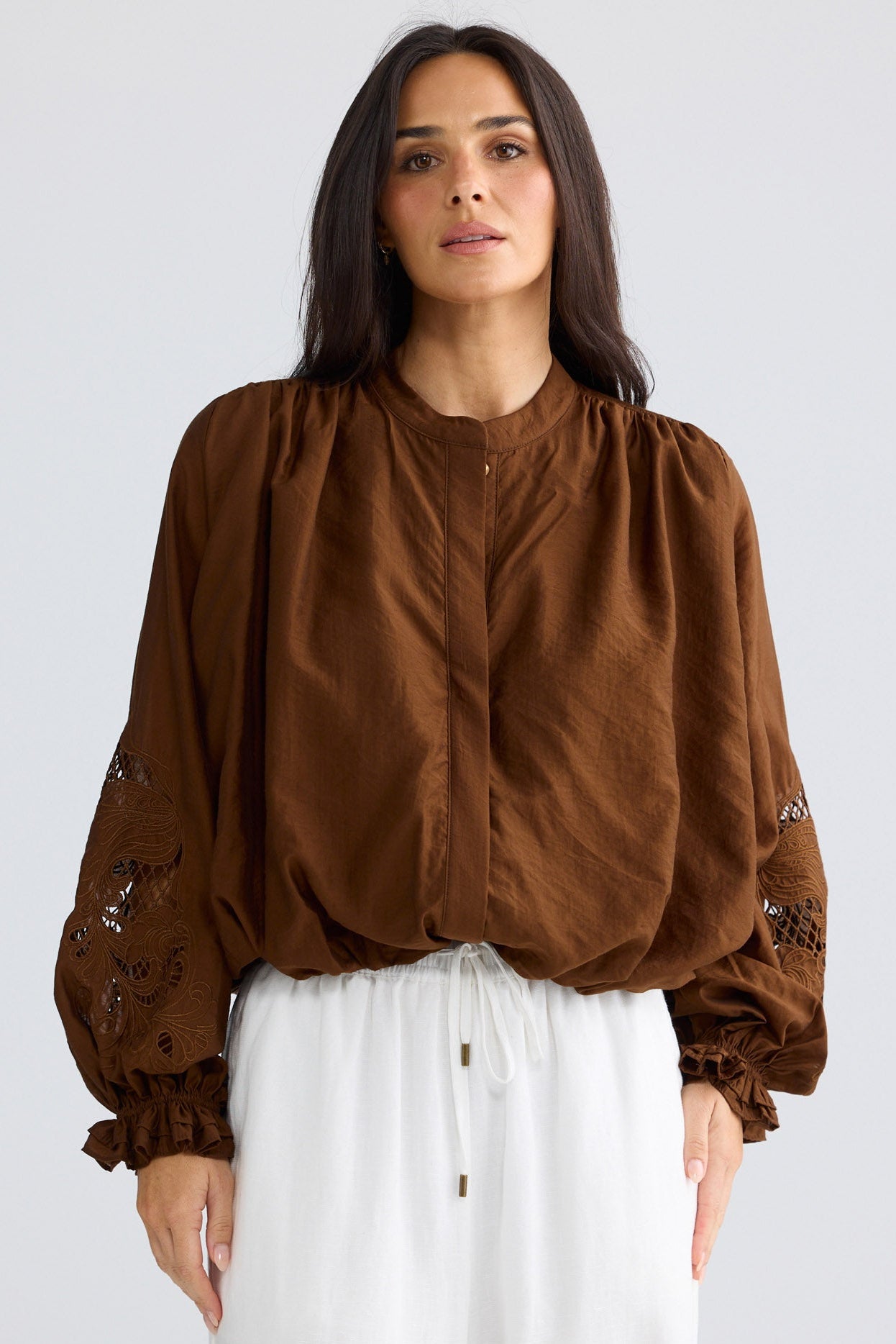 Model wearing Tiana Shirt in bronze brown by Brave + True, front view showing embroidered sleeves.