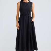 Model wearing Ren Midi Dress in black by Brave + True, front view showing waist belt.