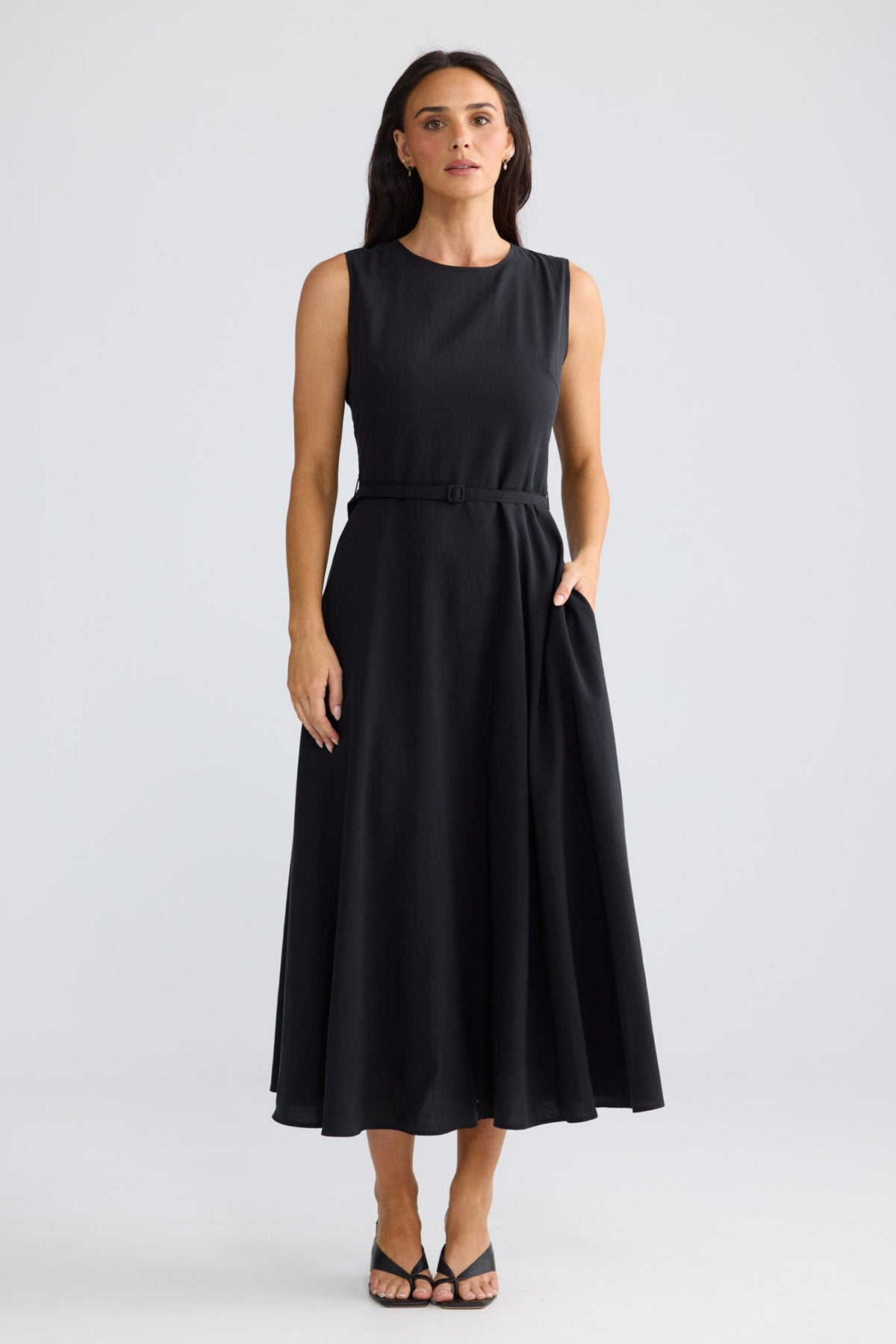 Model wearing Ren Midi Dress in black by Brave + True, front view showing waist belt.