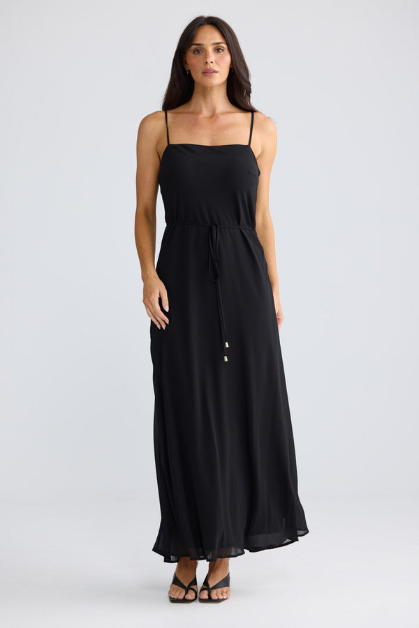 Model wearing Elsbeth Maxi Dress in black by Brave + True, front view showing square neckline.