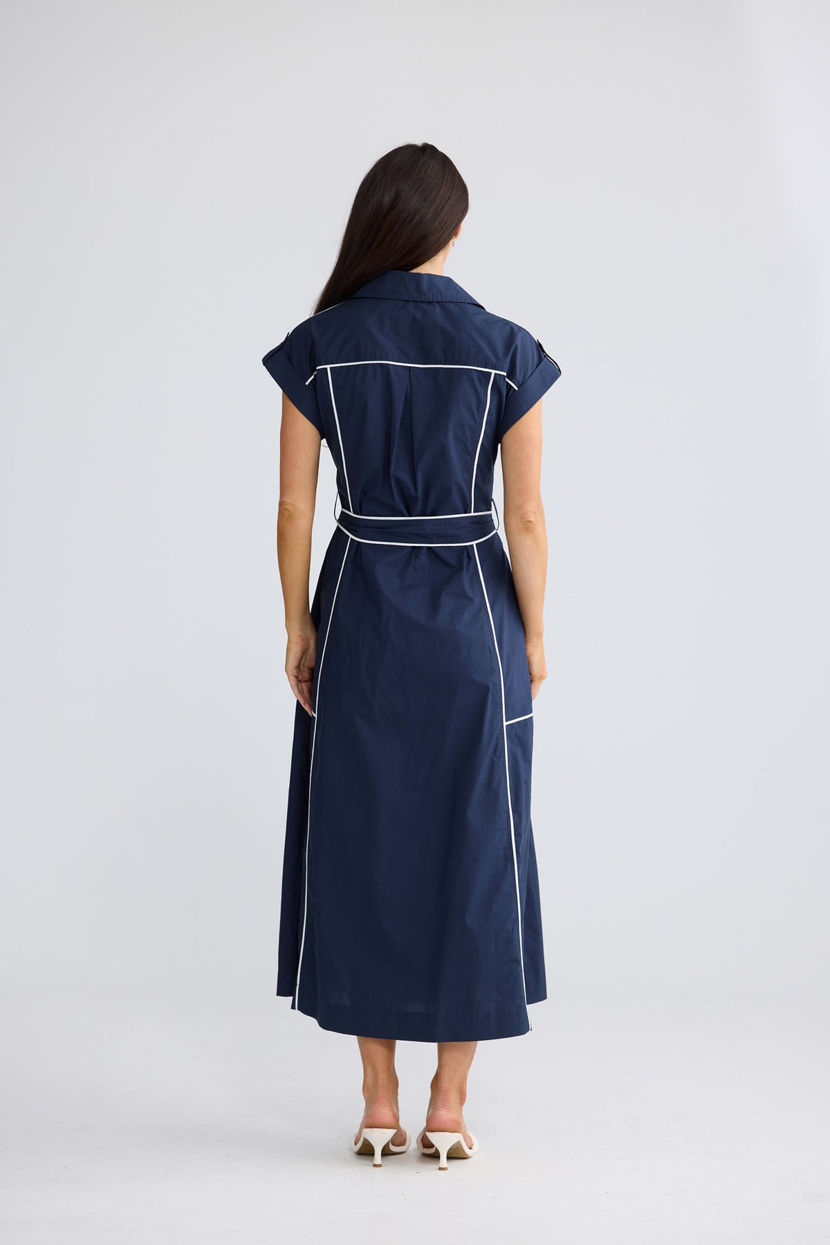 Model wearing Portia Dress in navy with white trim by Brave + True, front view.