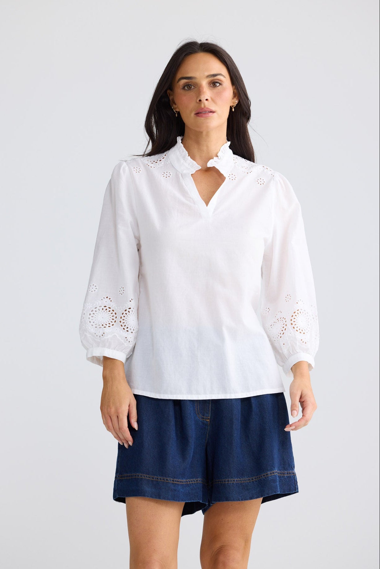 Model wearing Loretta Top in white by Brave + True, front view showing broderie sleeves.