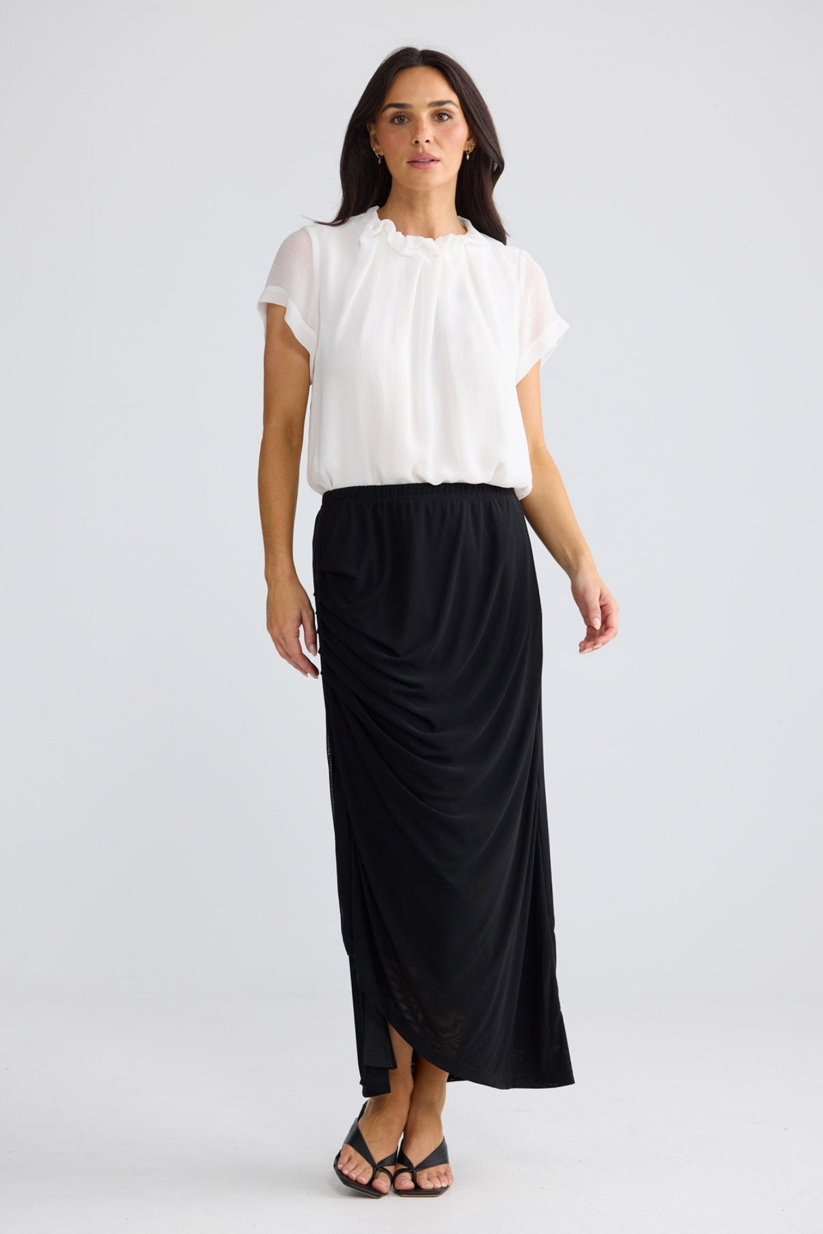 Model wearing Francine Skirt in black by Brave + True, front view showing draped front.