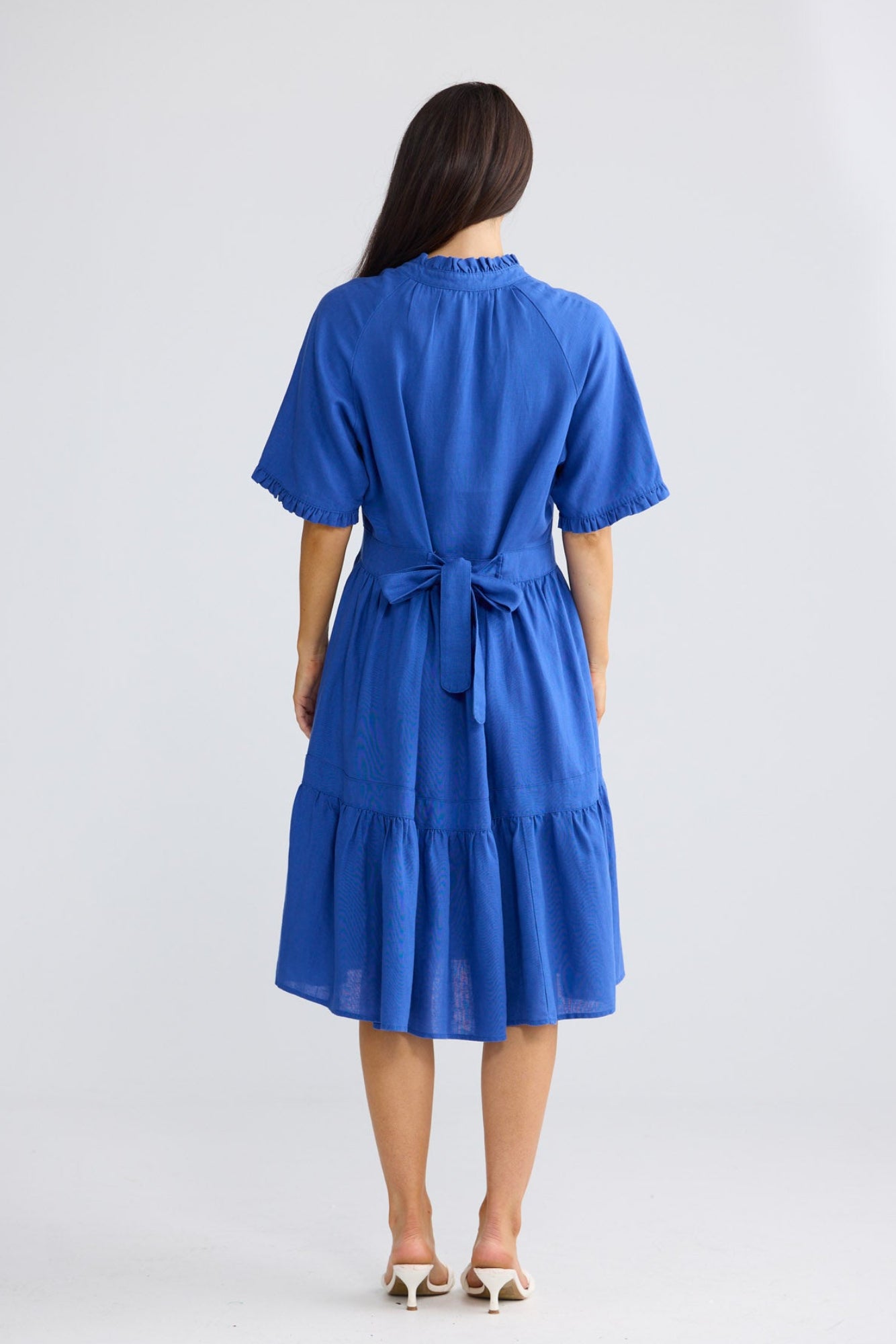 Model wearing Soiree Dress in cobalt blue by Brave + True, front view showing tiered skirt.