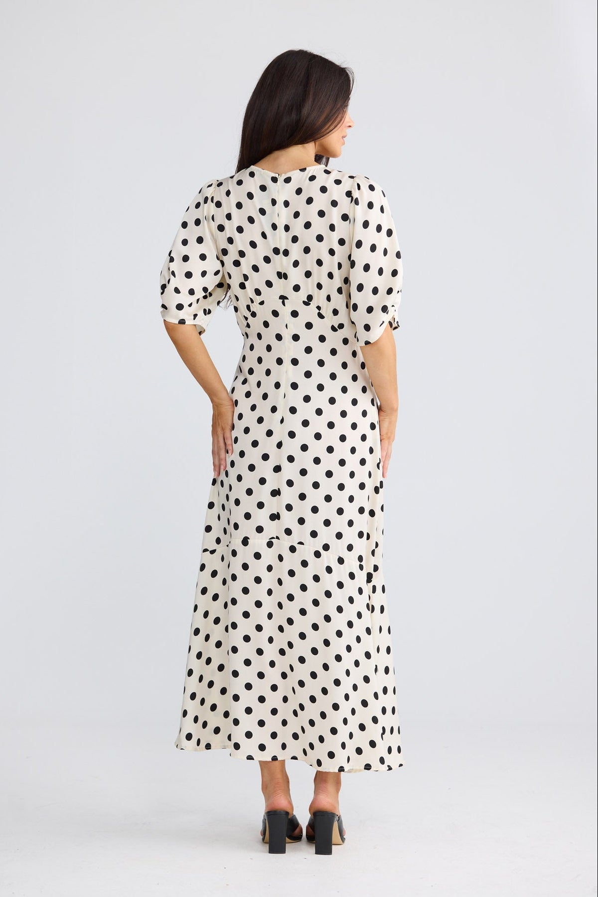 Model wearing Jocelyn Dress in ivory spot by Brave + True, front view showing puff sleeves.