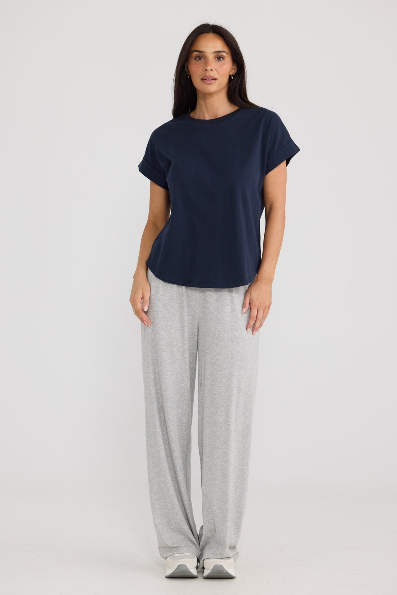 Model wearing Sandra Tee in navy by Brave + True, front view with turn-back sleeves.