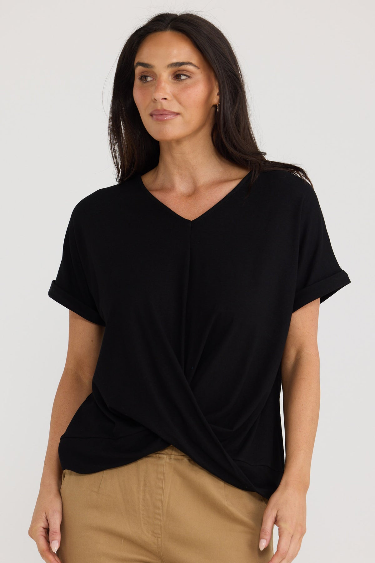Model wearing Rapture Tee in black by Brave + True, front view with twist front.