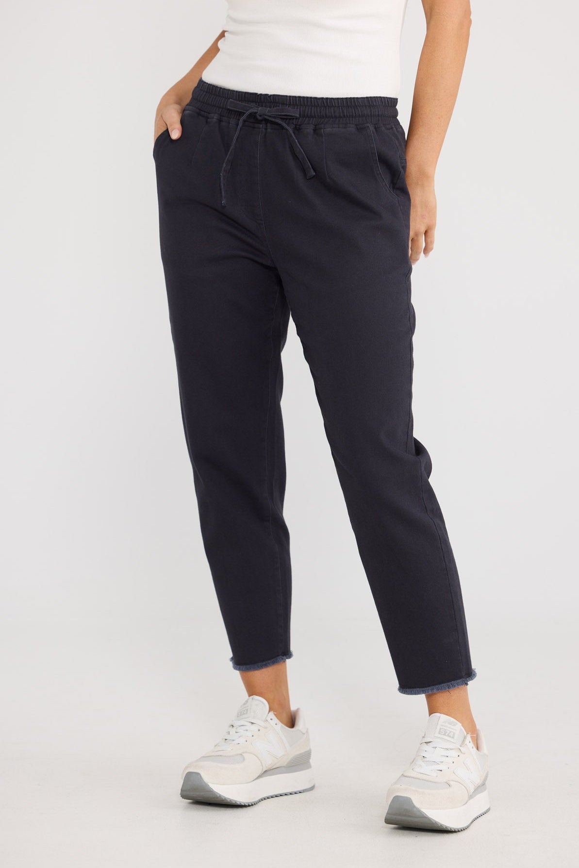 Model wearing Wayfarer Pant in navy by Brave + True, front view with drawstring waist.