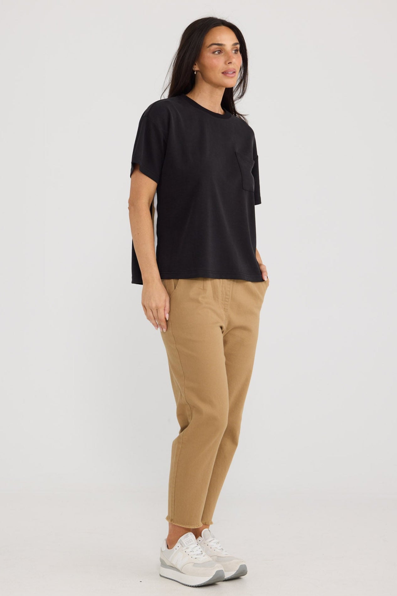 Model wearing Wayfarer Pant in taupe by Brave + True, front view with tapered leg.