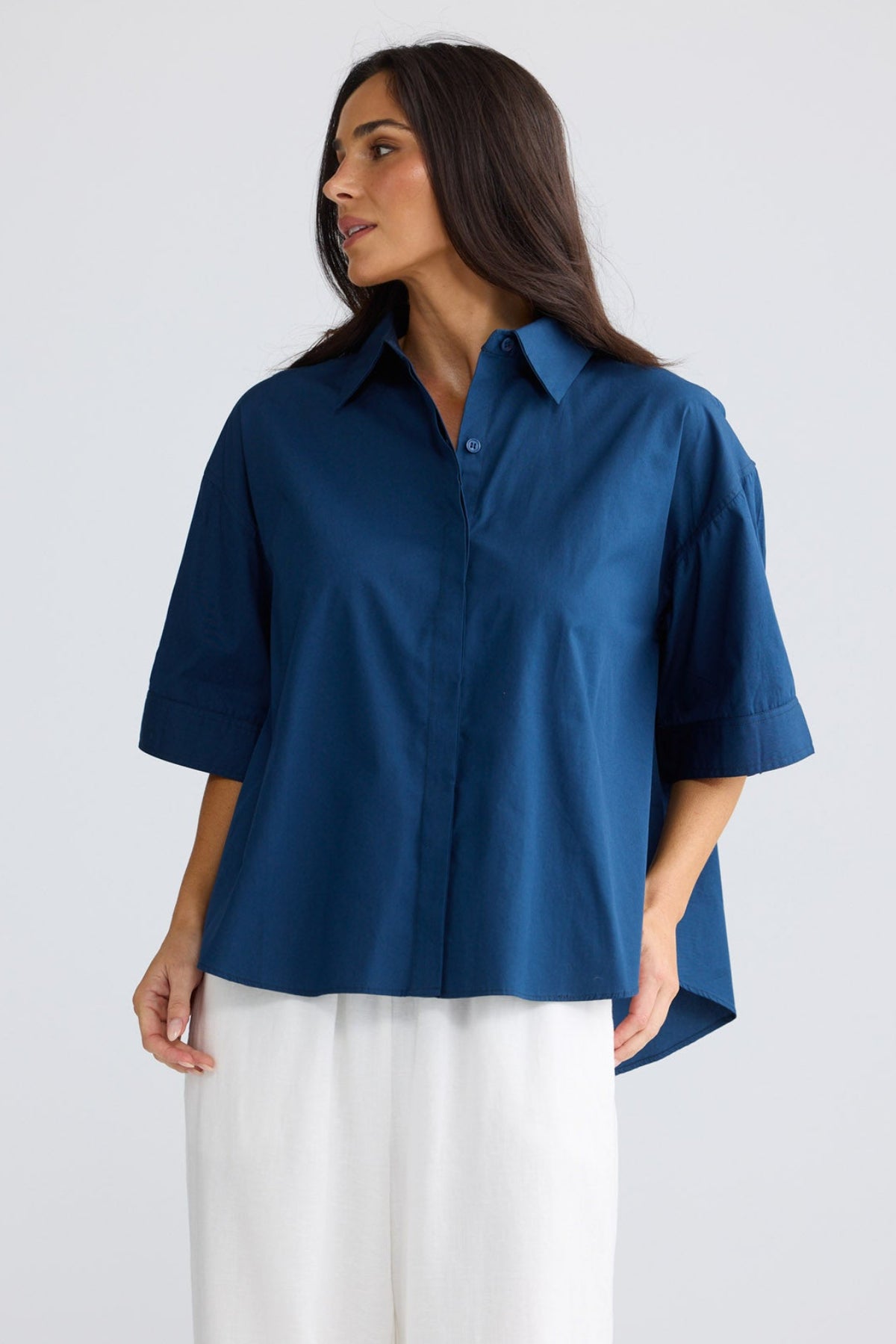 Model wearing Rachel Shirt in navy by Brave + True, front view with short sleeves.