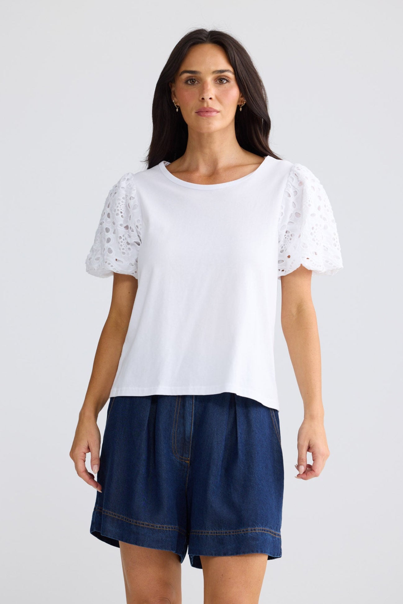 Model wearing Molly Tee in white by Brave + True, front view with broderie sleeves.
