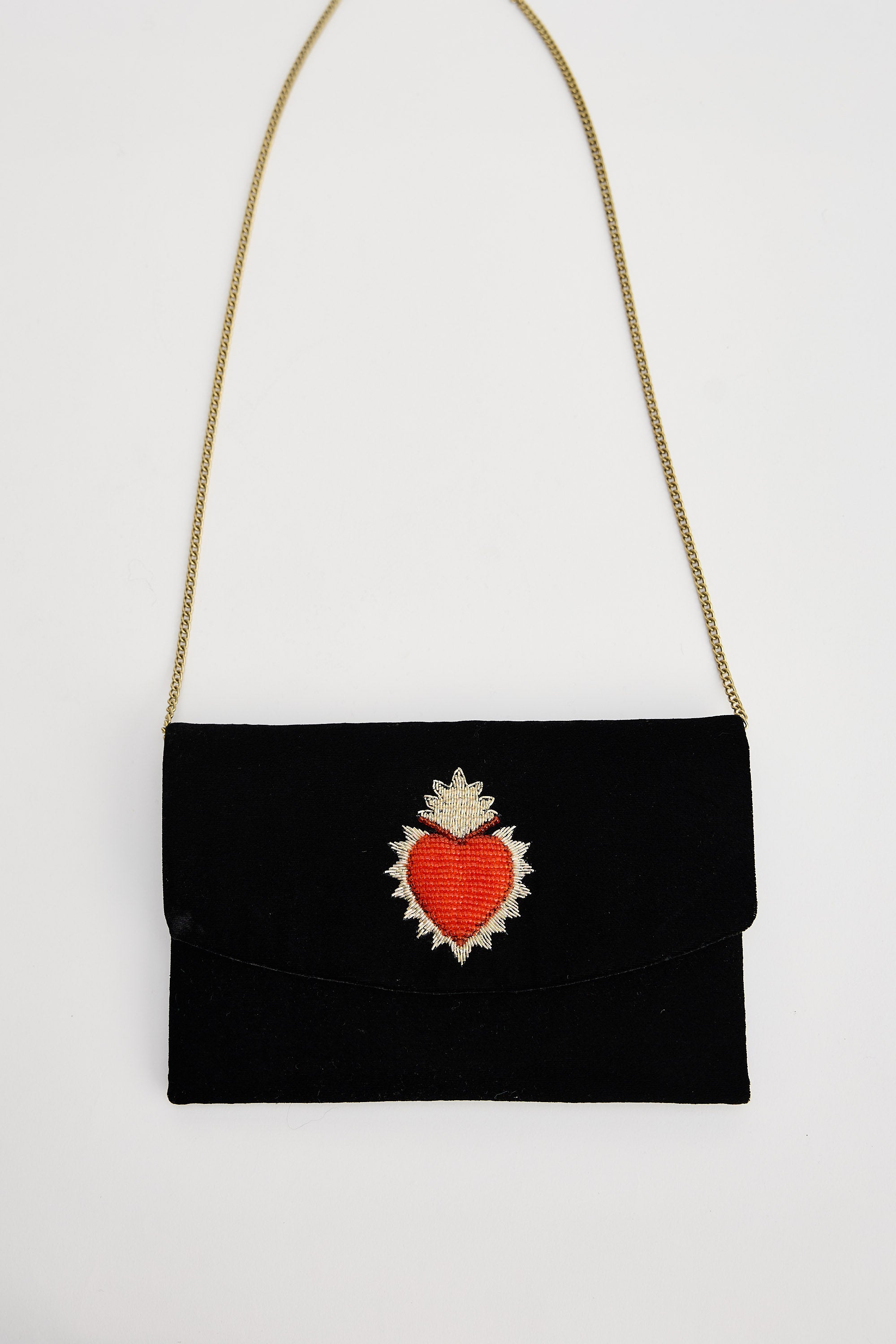 Black clutch bag with a red heart design on a white background
