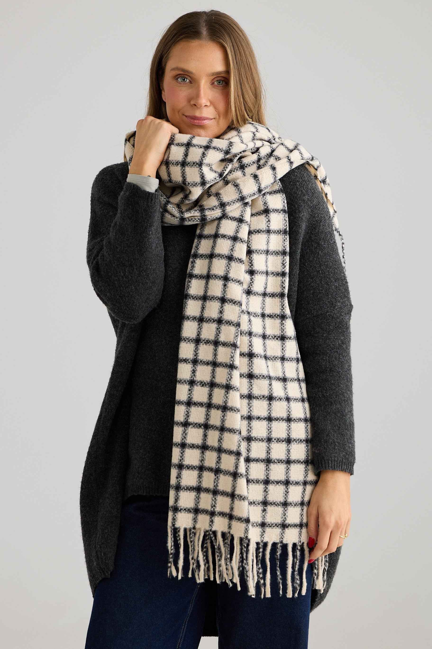 Woman wearing a checkered scarf with a plain background