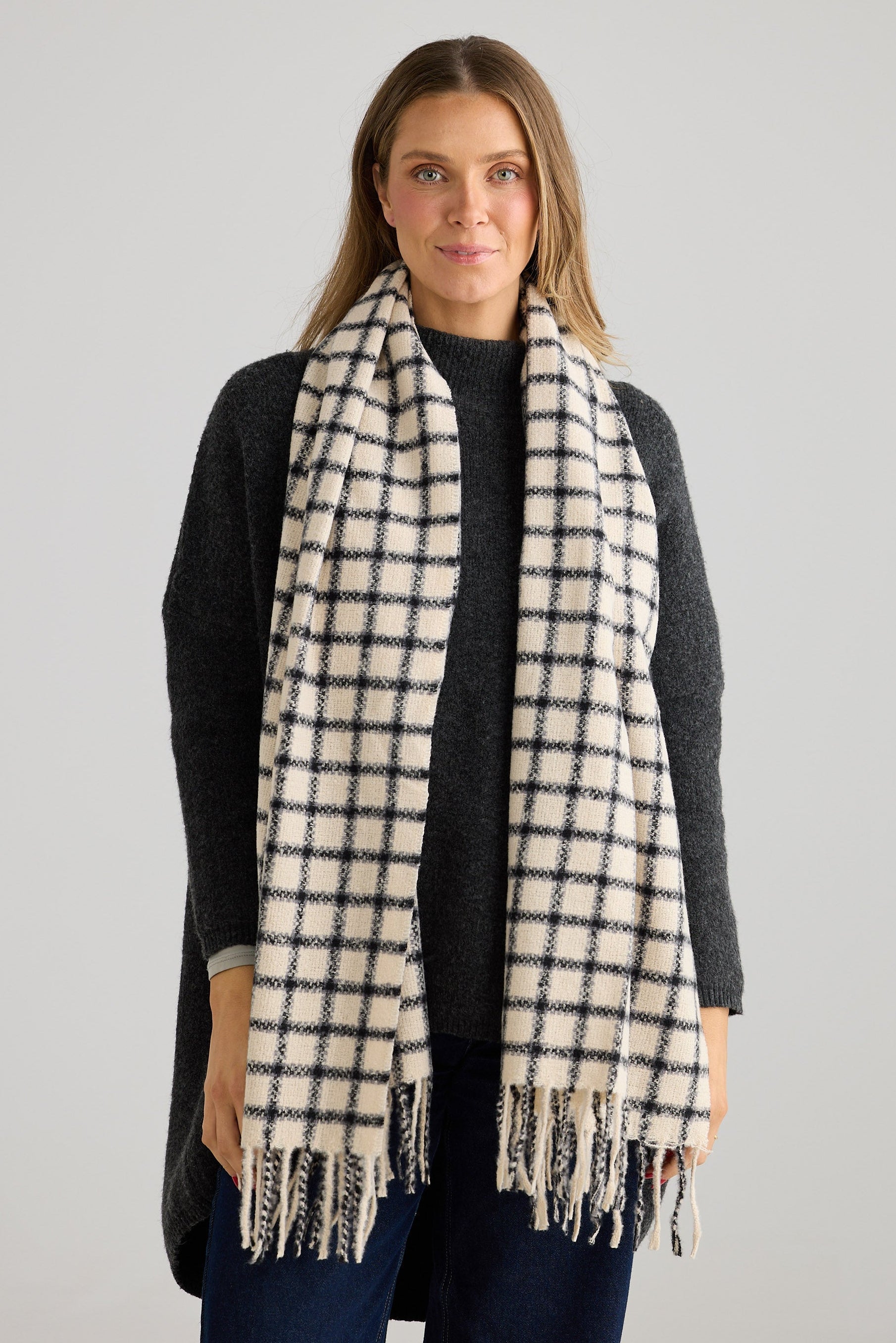 Woman wearing a plaid scarf on a gray background