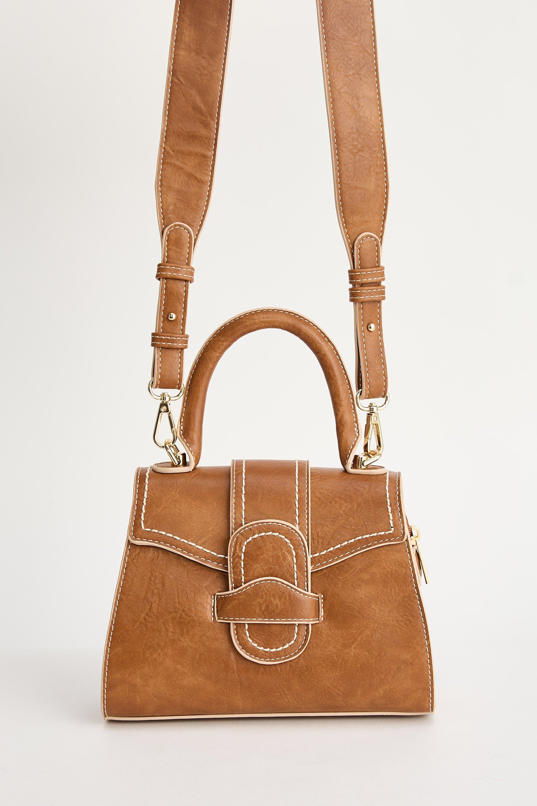 Brown handbag with a strap on a light gray background