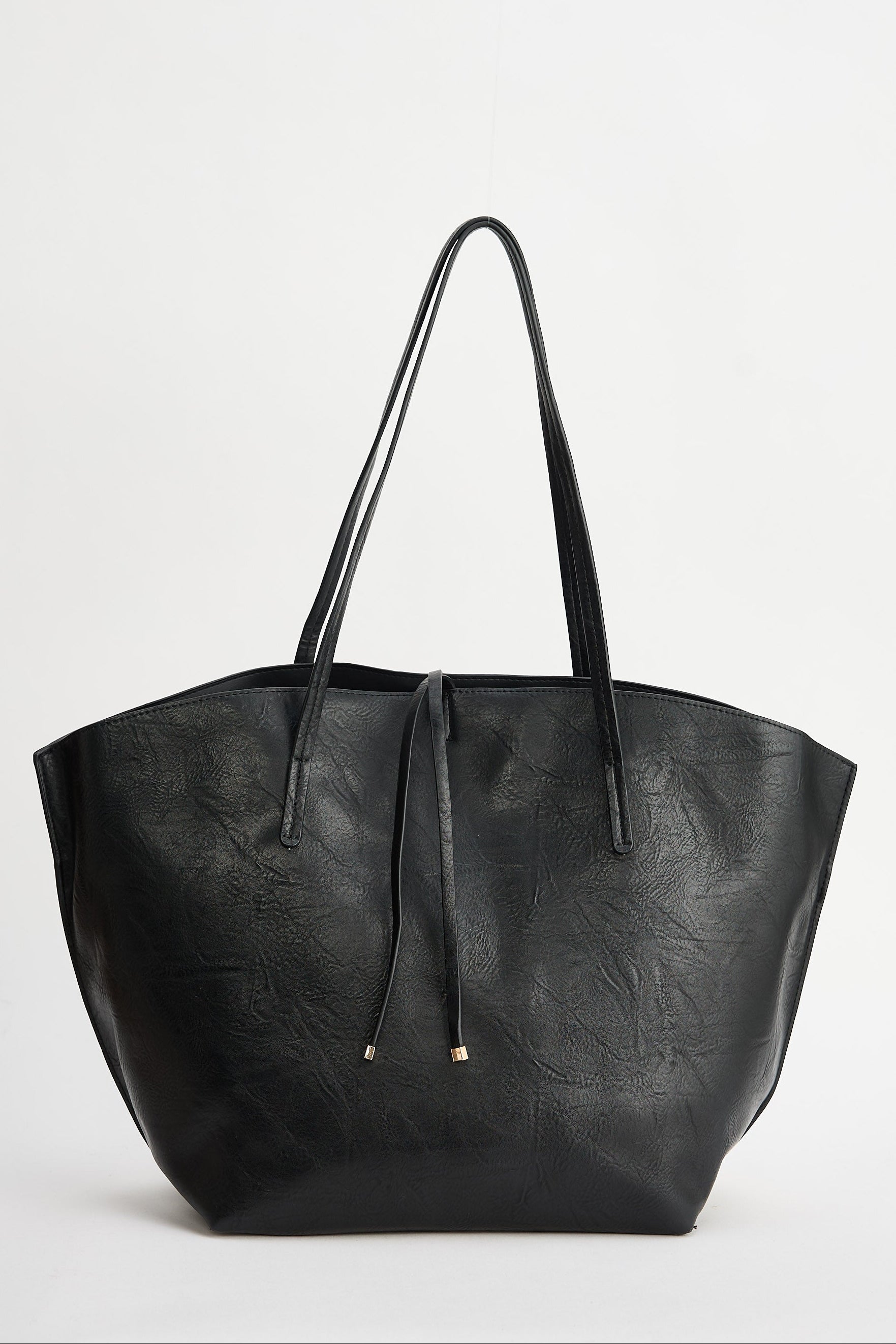 Black leather tote bag on a light gray background