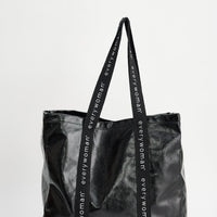 Black tote bag with 'everywoman' branding on a white background