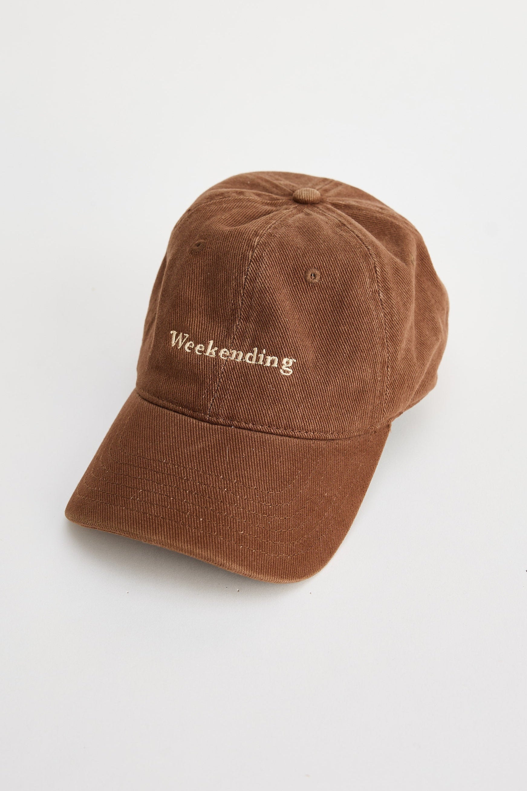Brown cap with 'Weekending' text on a light gray background