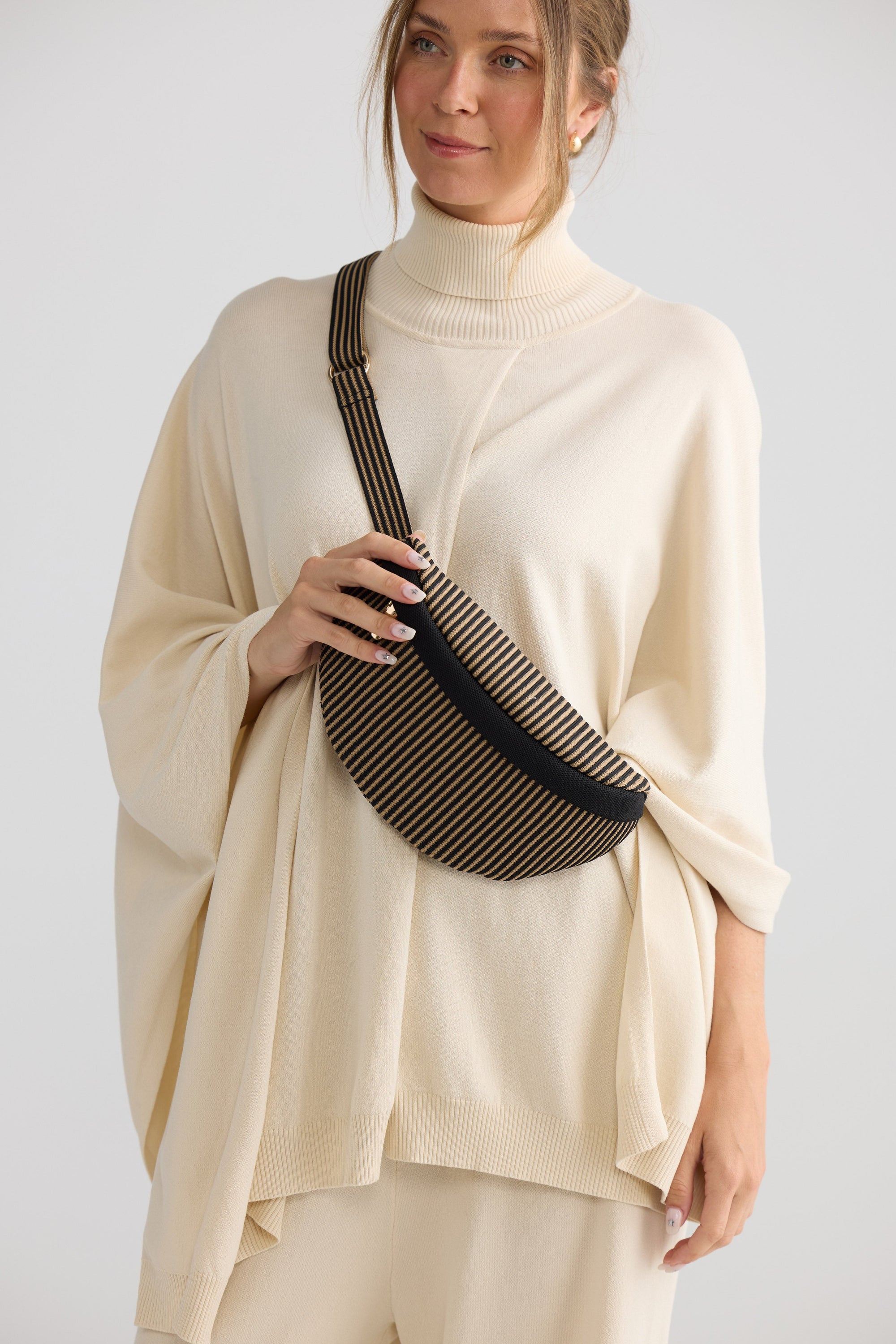 Delphi Bumbag - Black bum bag in black with stripe detailing, side view.
