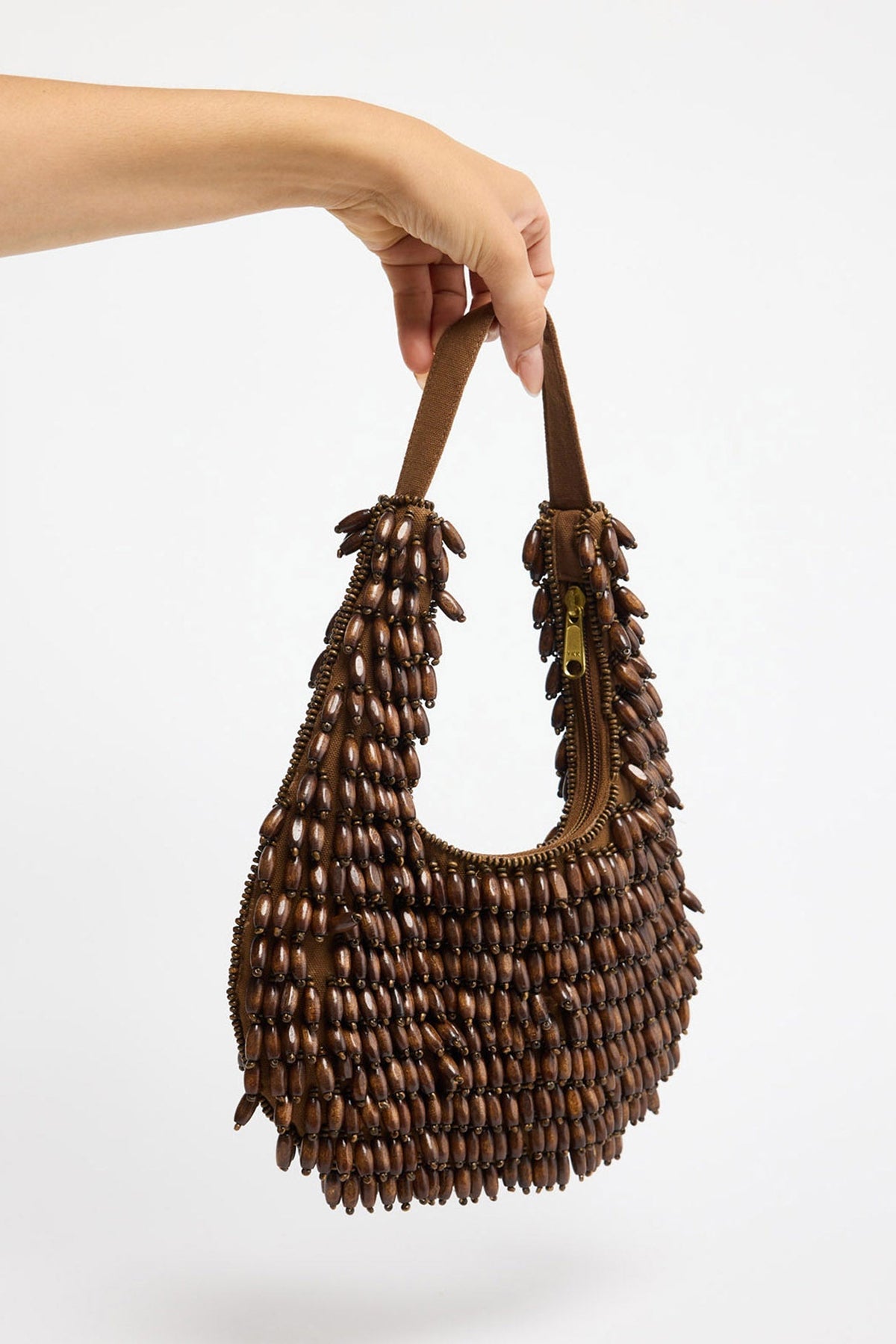 Half-moon shaped beaded clutch bag in chocolate brown and cream tones with a diamond lattice pattern, floral bead accents and gold-tone chain strap, shown hanging against a white background