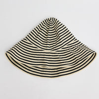 Wide-brim bucket hat in cream and black horizontal stripes with a soft unstructured crown, shown flat on a white background