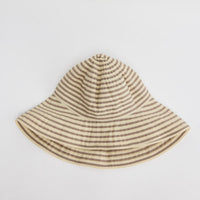 Wide-brim bucket hat in cream and taupe horizontal stripes with a soft unstructured crown, shown flat on a white background