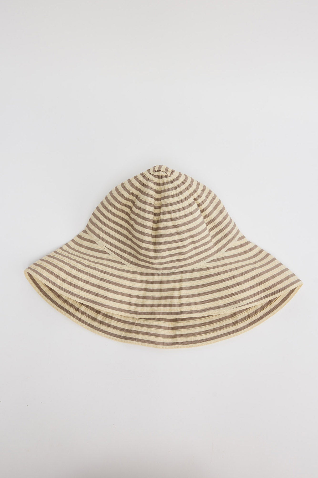 Wide-brim bucket hat in cream and taupe horizontal stripes with a soft unstructured crown, shown flat on a white background