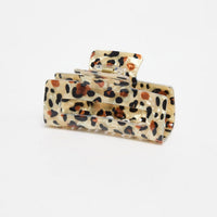 Zali Hair Claw in cheetah-print acetate, shown at an angle highlighting the rectangular shape and gold spring hinge