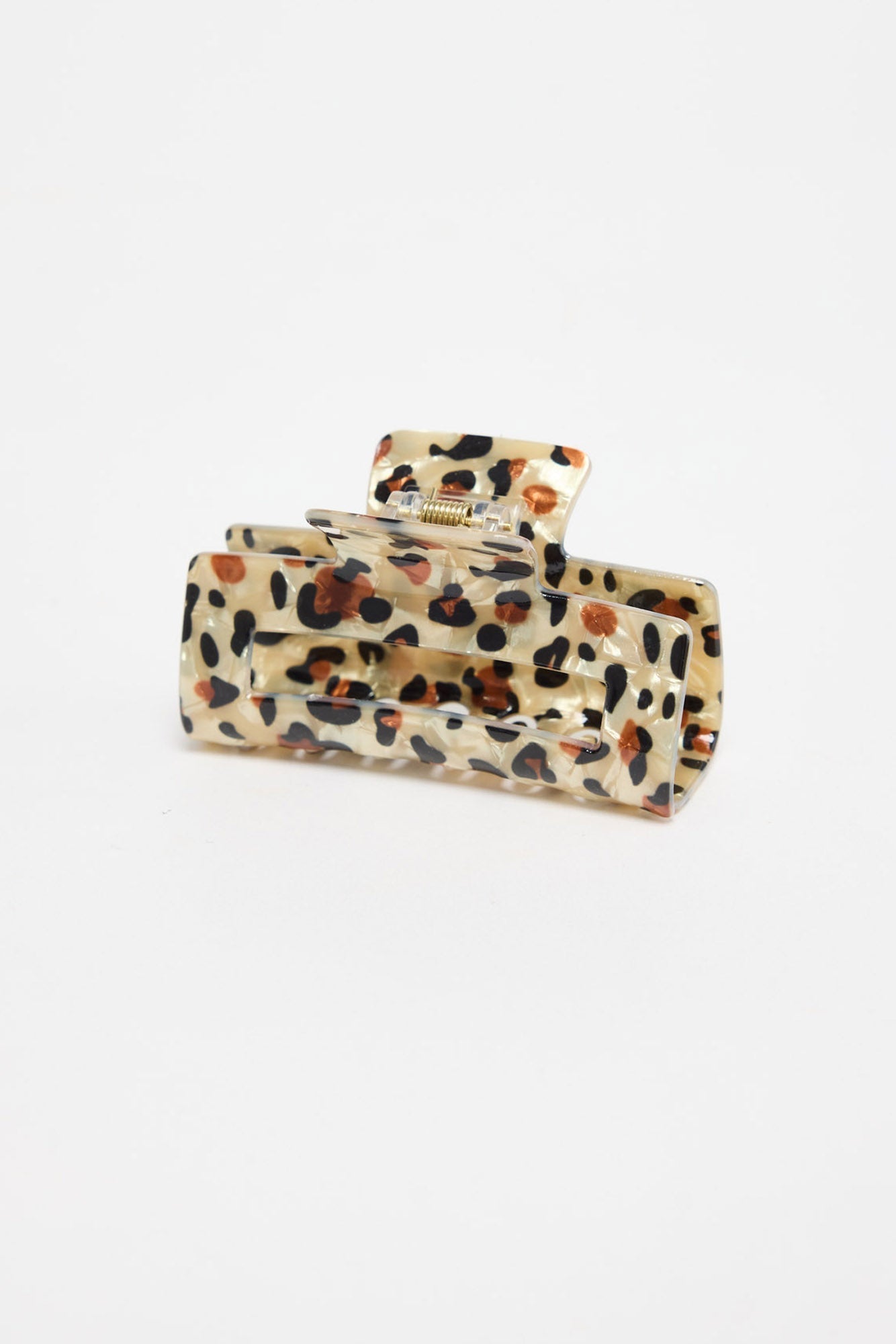 Zali Hair Claw in cheetah-print acetate, shown at an angle highlighting the rectangular shape and gold spring hinge