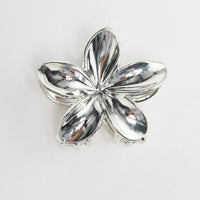 Frangi Hair Claw in silver - flat lay view of the plumeria flower-shaped metal hair claw