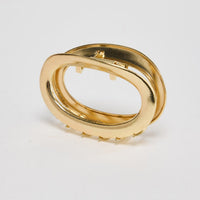 Noosa Hair Claw in gold - angled view of the sleek oval metal hair claw