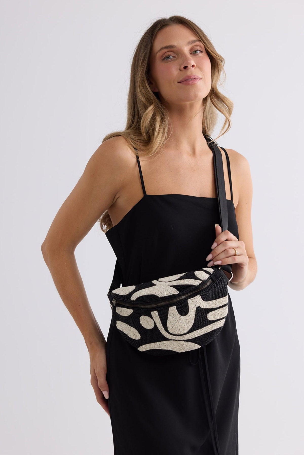 Waves Bumbag in black and white worn at the waist, close-up front view