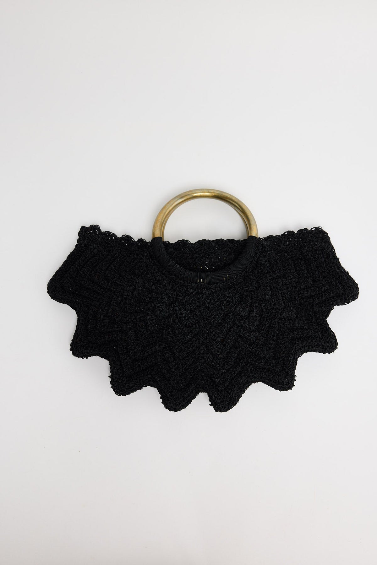 Santana Bag in black - handwoven crochet bag with scalloped chevron edges and brass-tone ring handles, flat lay