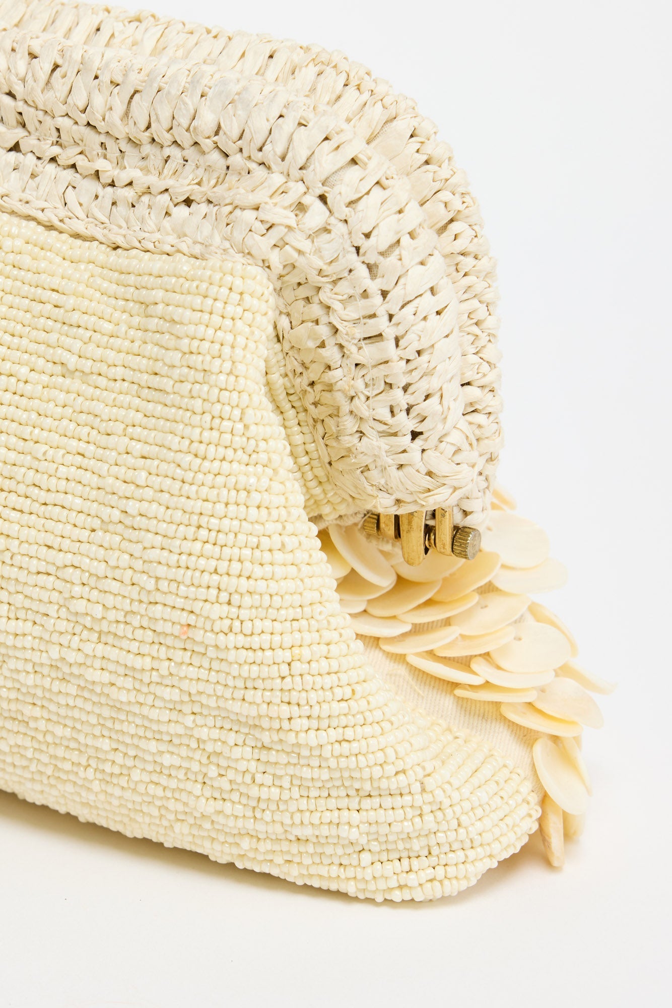 Sandy Clutch in creme - macro detail of the layered mother-of-pearl shell discs and frame clasp